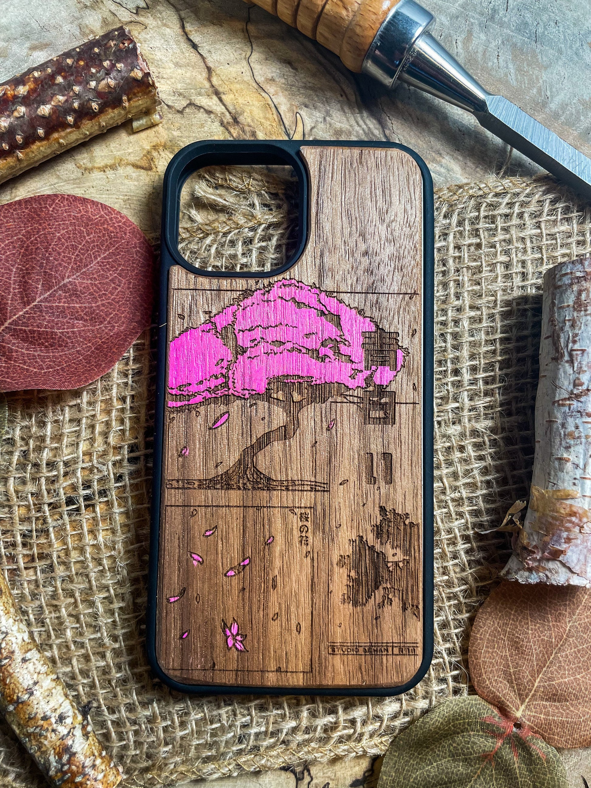 a wooden phone case with a pink design on it