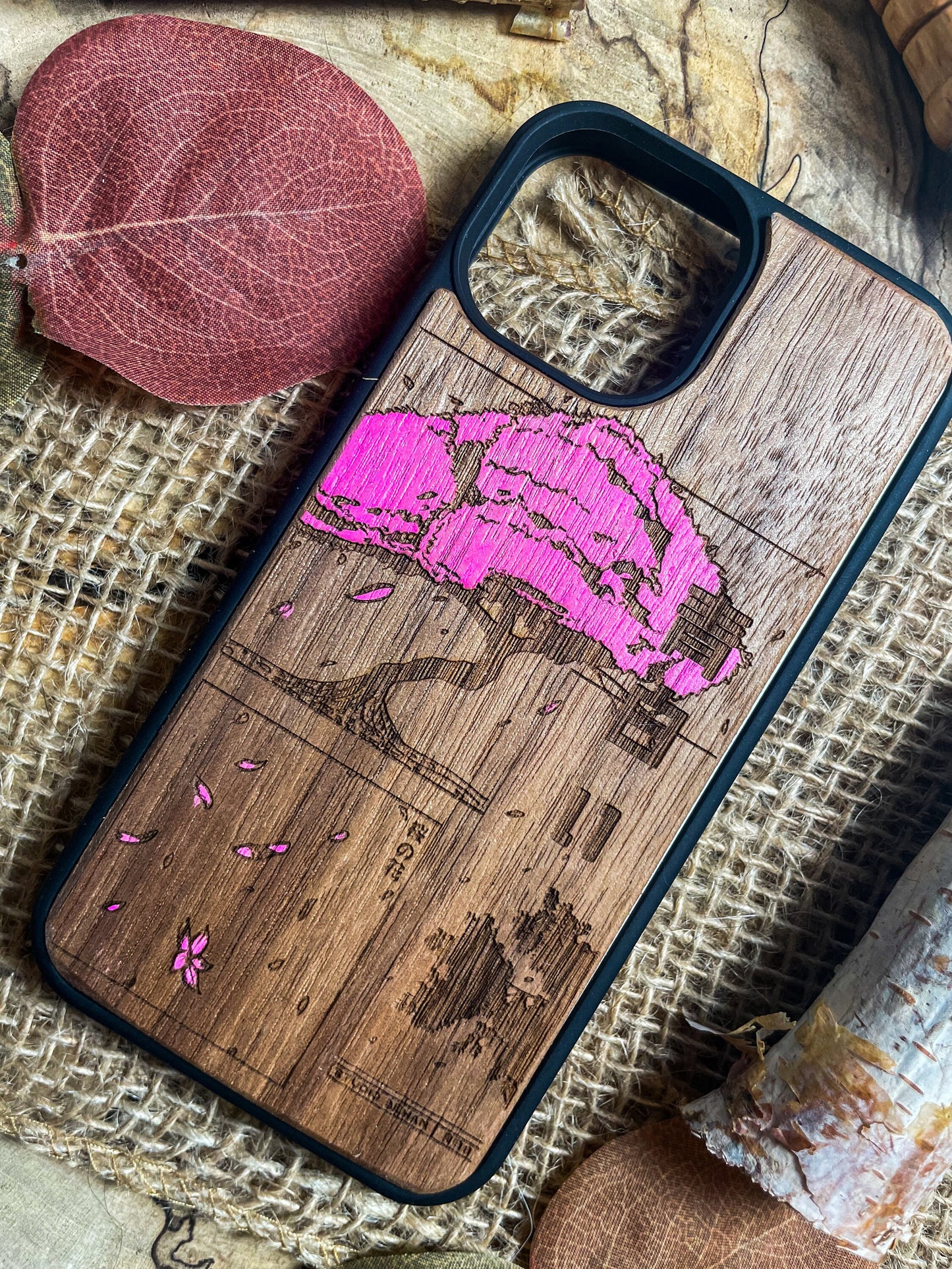 a wooden phone case with a pink design on it