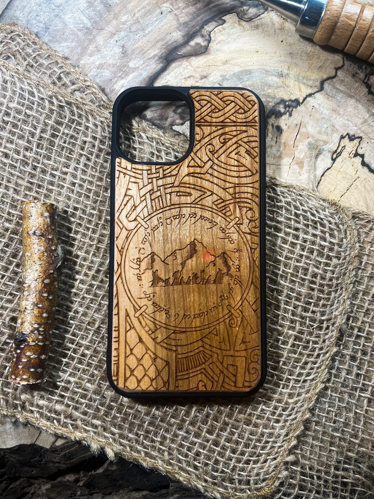 a wooden phone case sitting on top of a piece of fabric