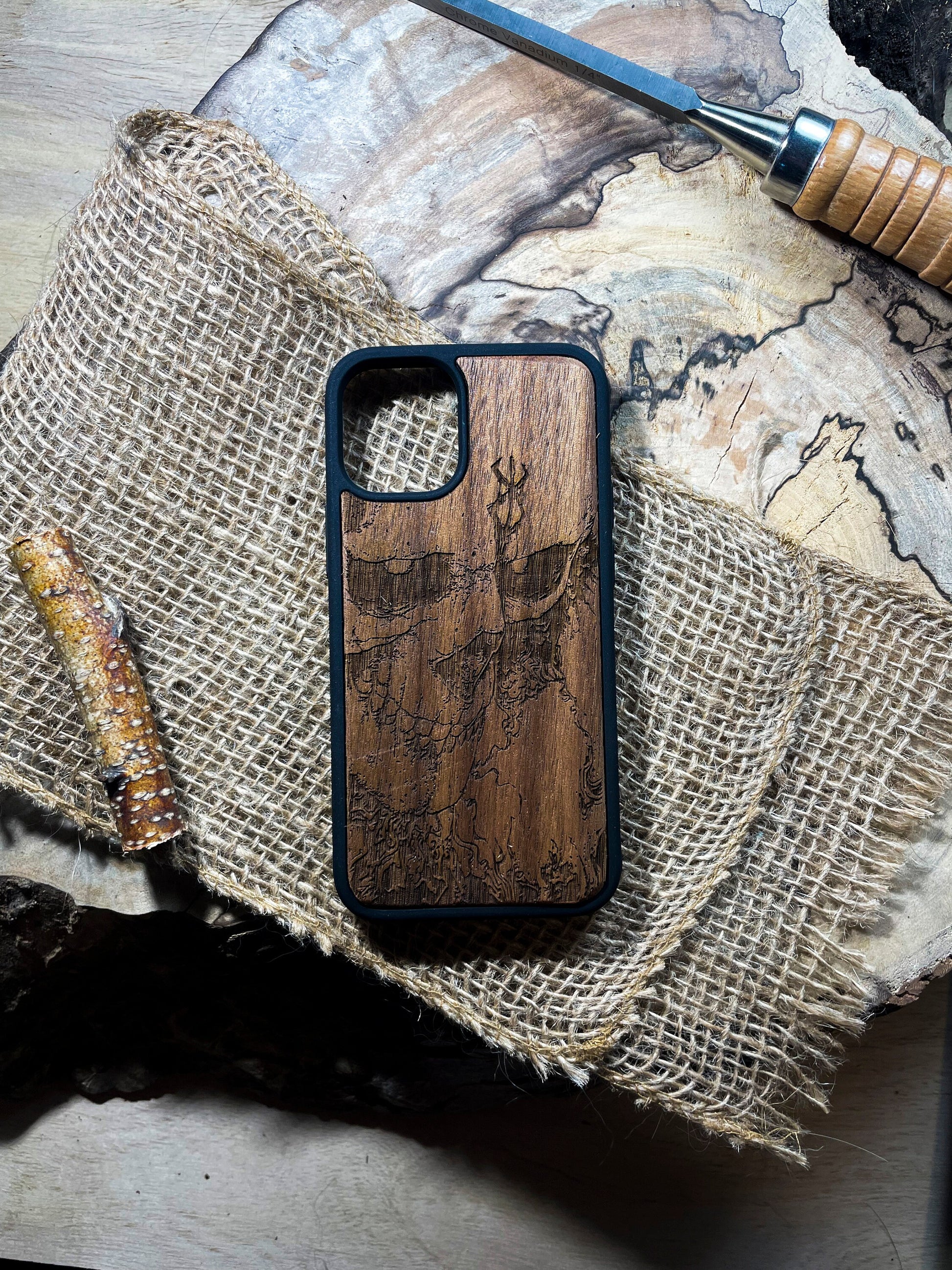 a wooden phone case sitting on top of a piece of wood