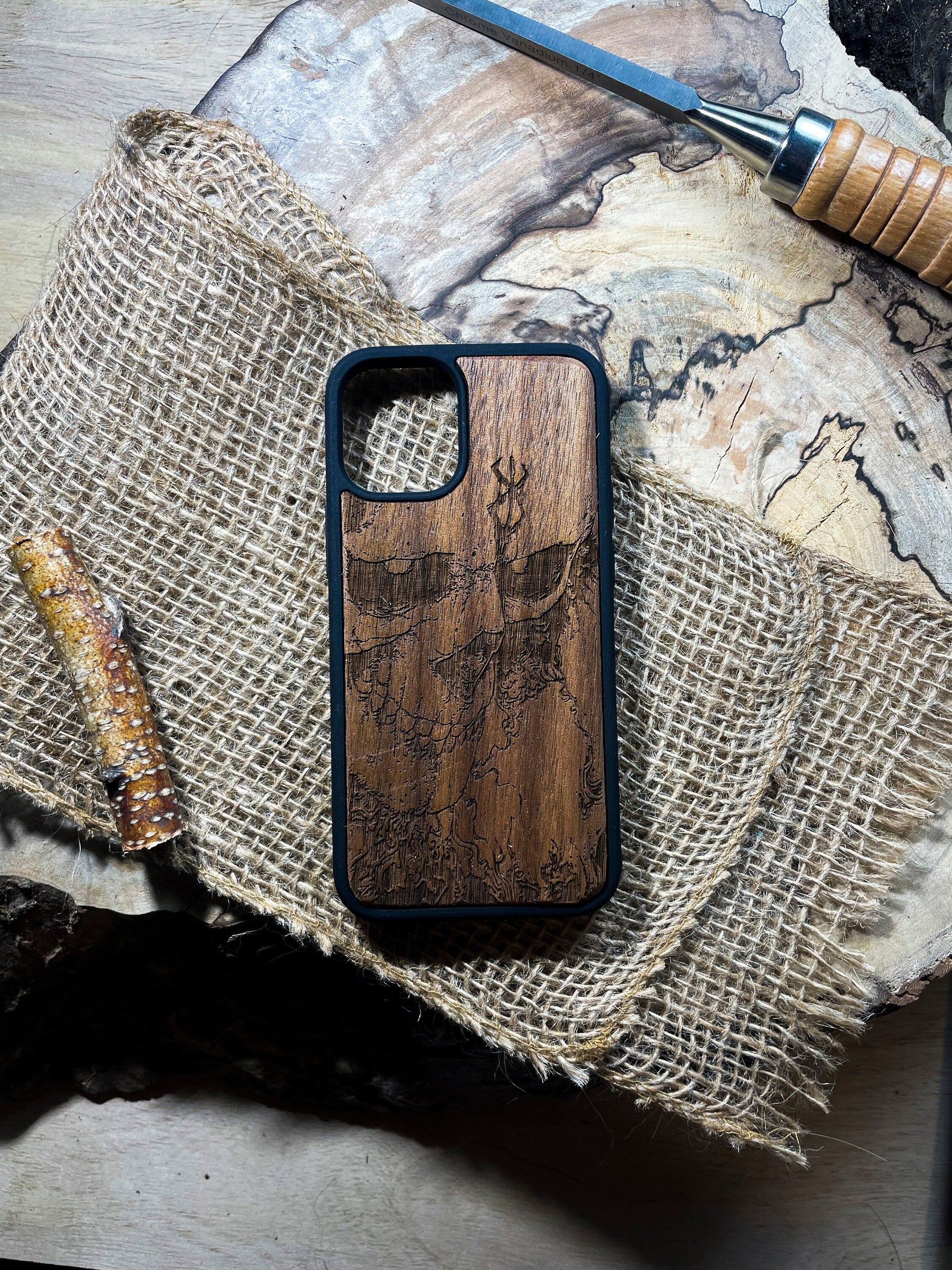 a wooden phone case sitting on top of a piece of wood