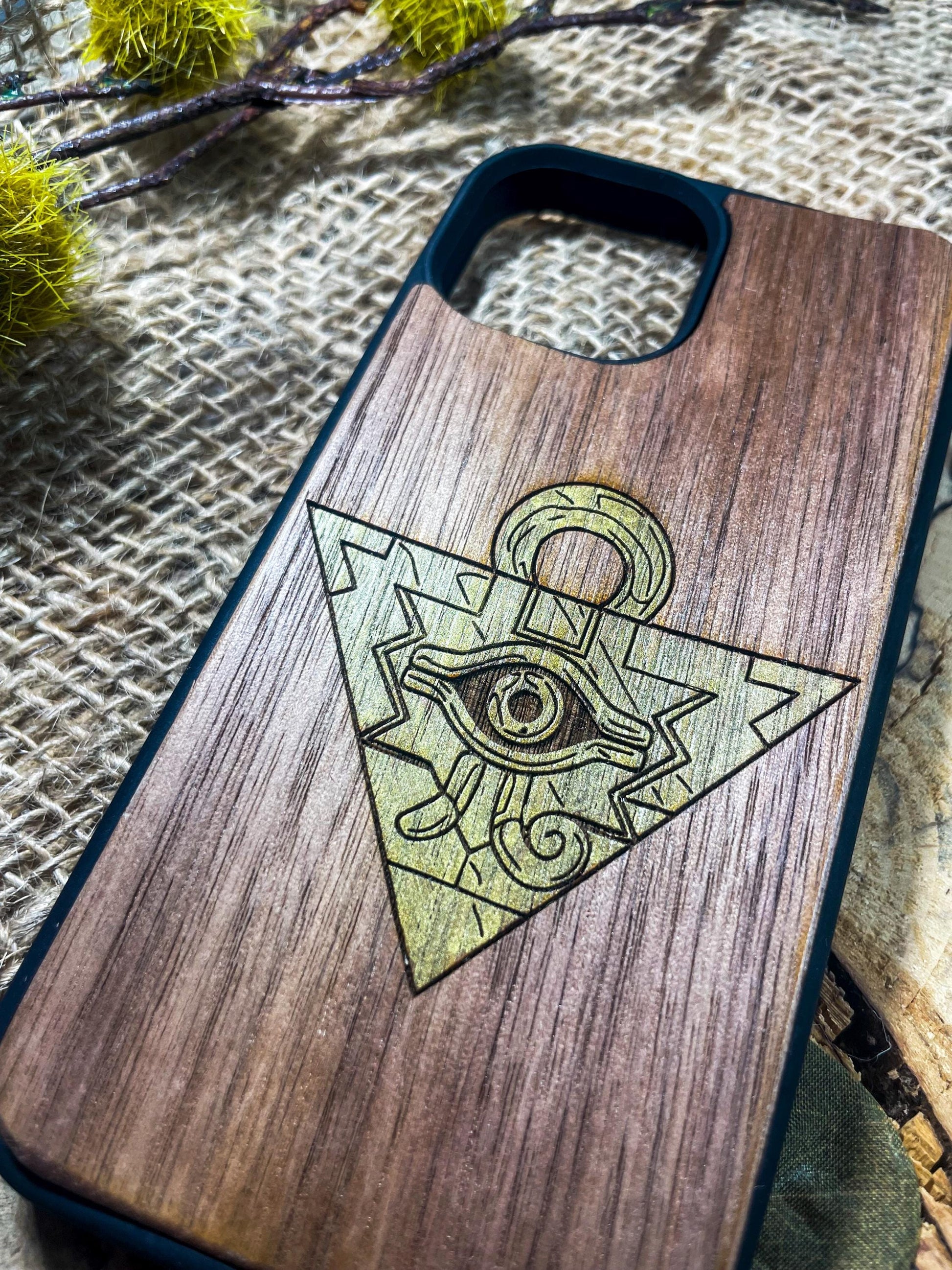 a wooden phone case with an all seeing eye on it