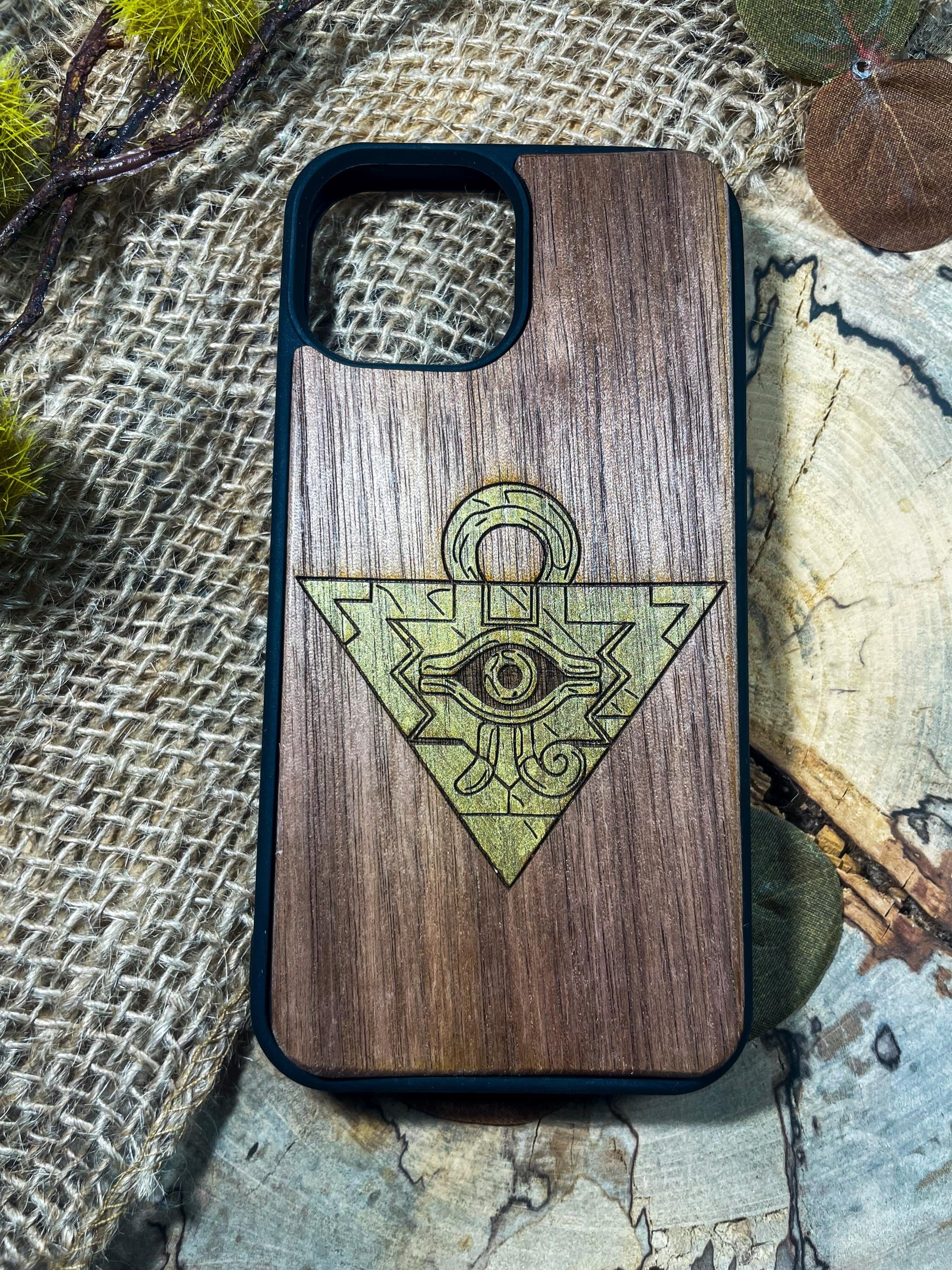 a wooden phone case with an all seeing eye on it