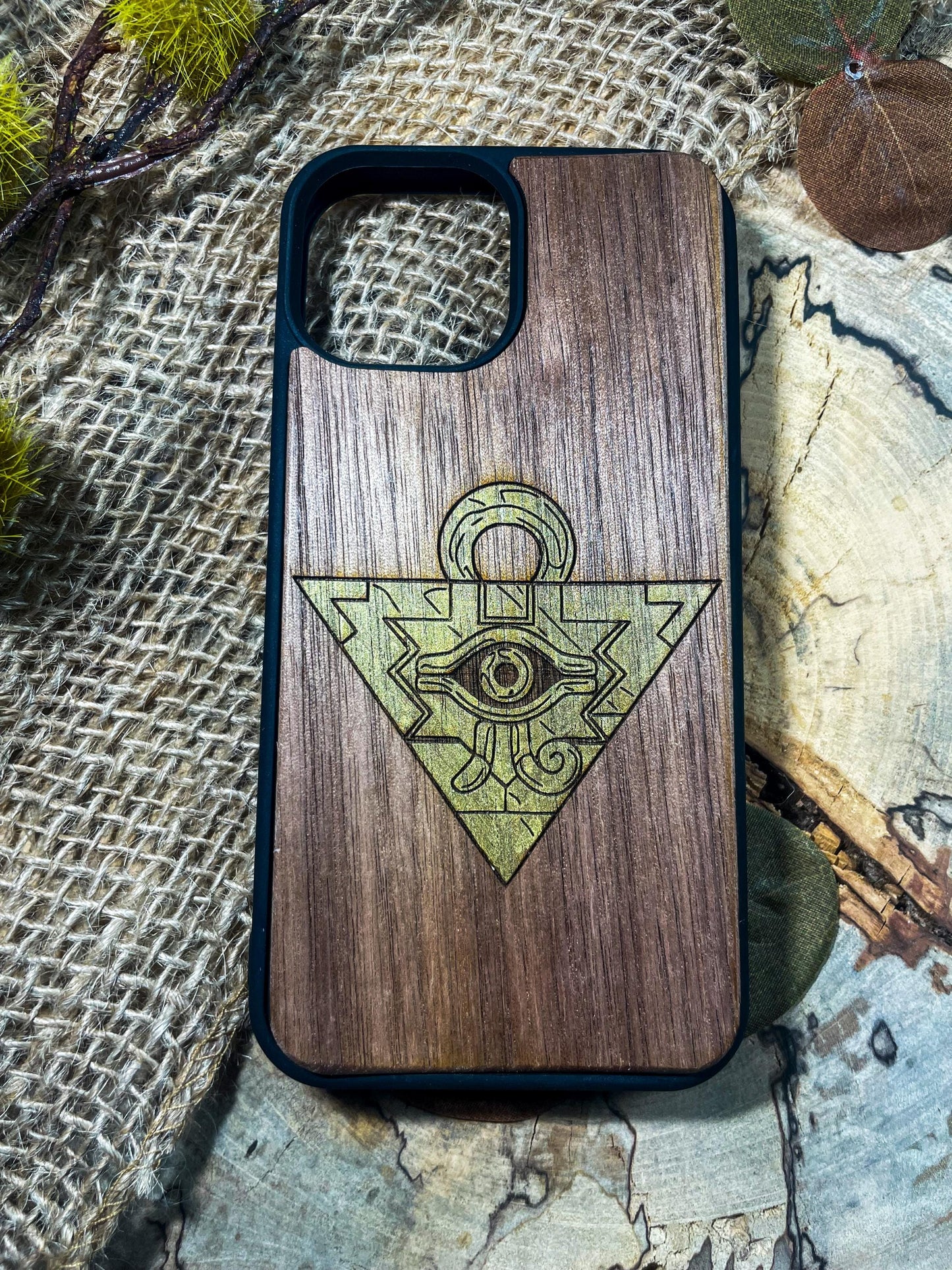 a wooden phone case with an all seeing eye on it