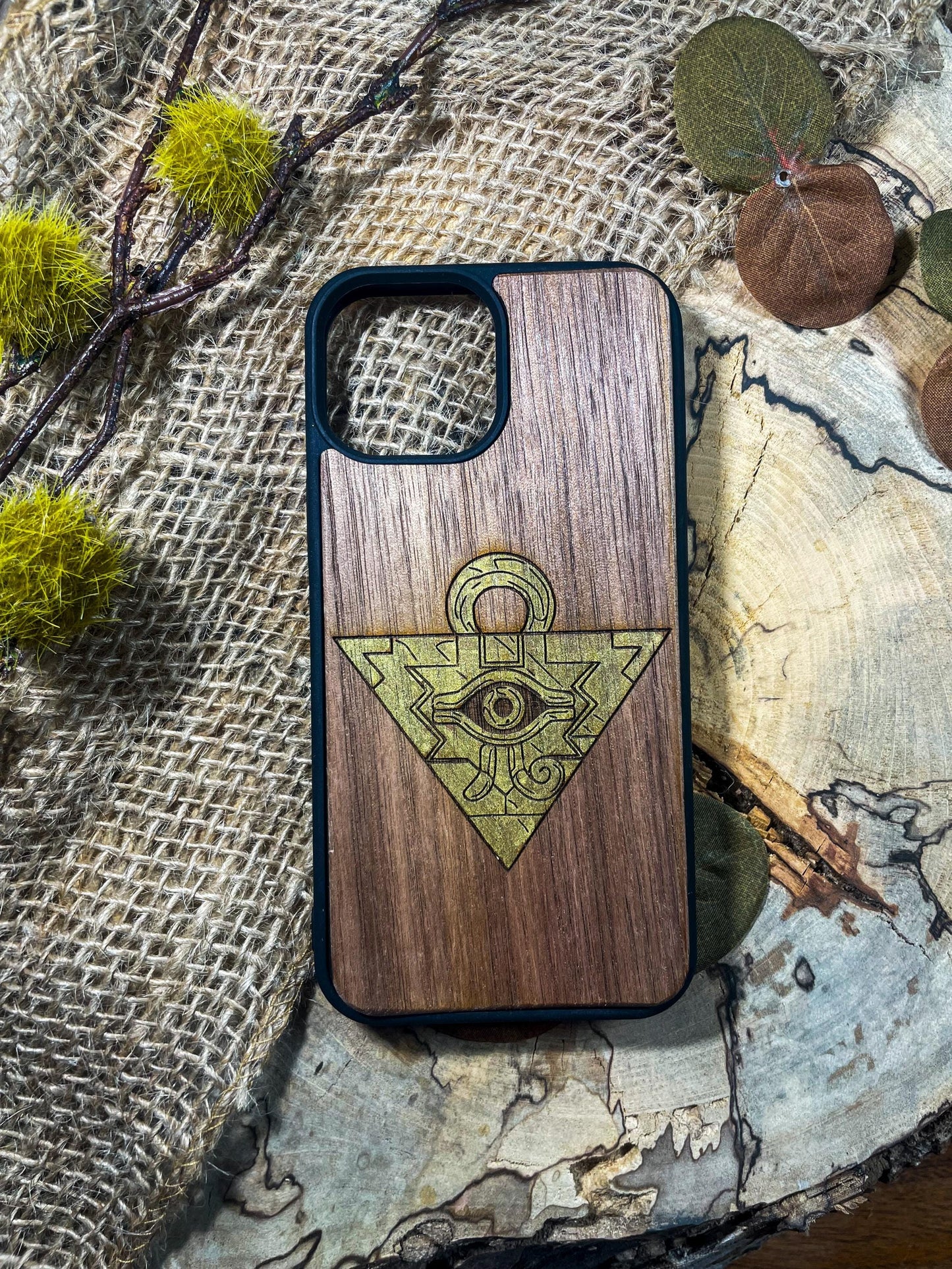 a wooden phone case with an all seeing eye on it