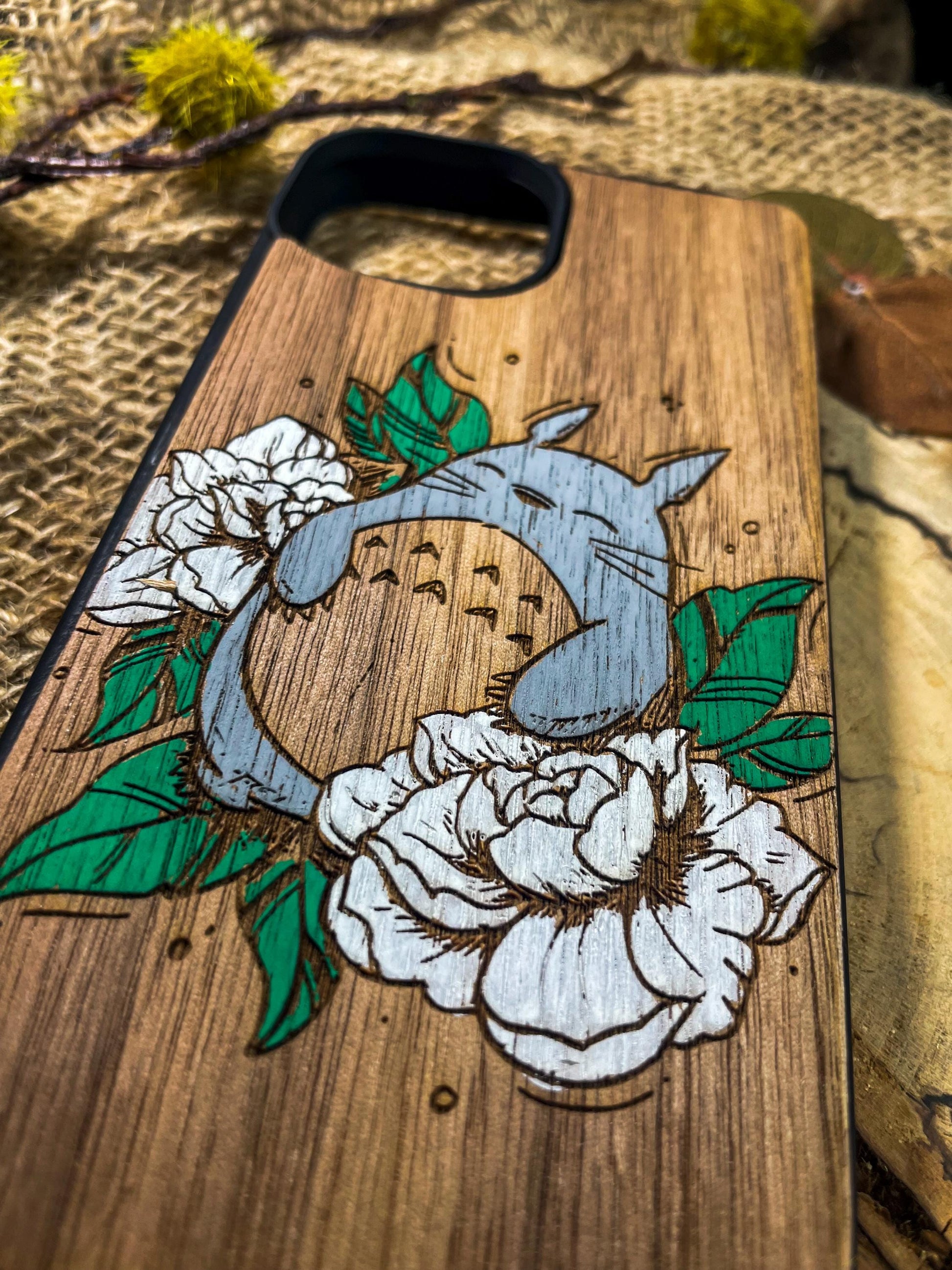 a wooden phone case with a picture of a bird and flowers on it